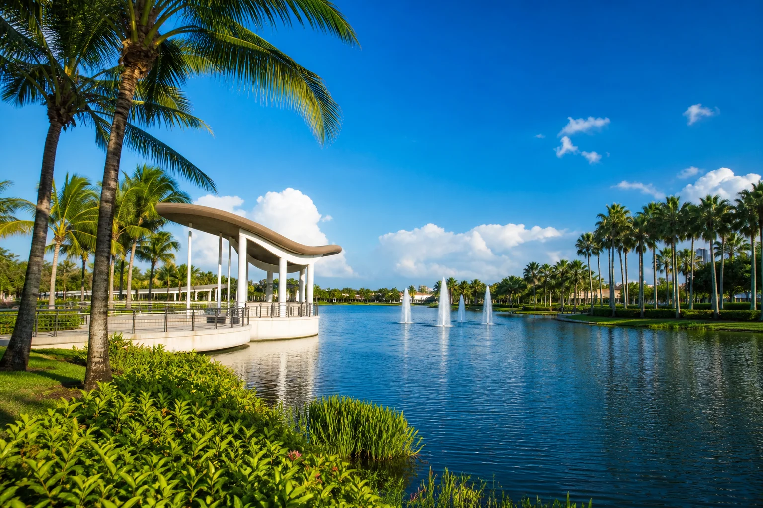 Miramar community lake with fountain, stone pavilion, and palm trees