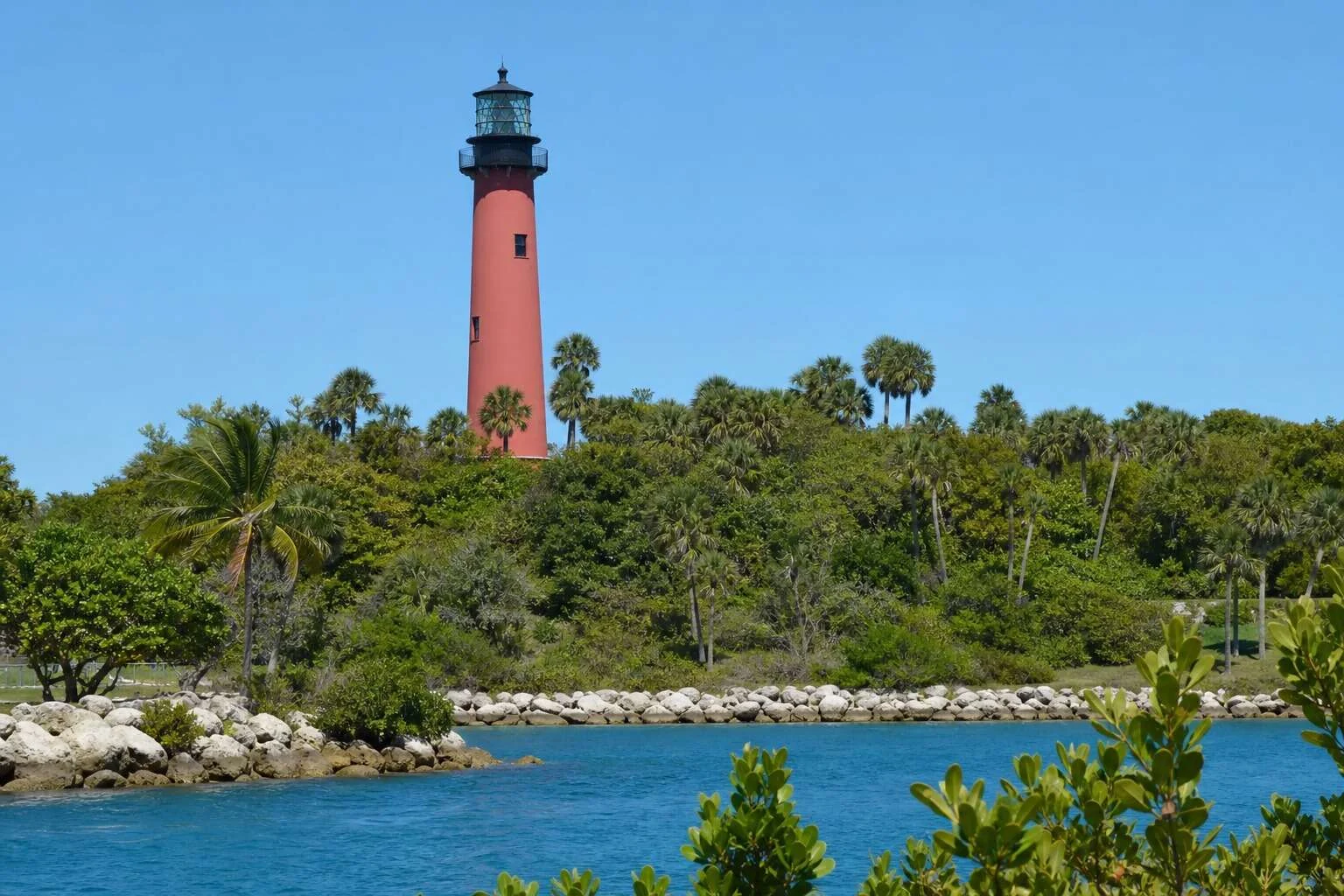 Jupiter Inlet Lighthouse beside blue inlet water